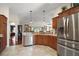 Spacious kitchen featuring stainless steel appliances, wood cabinets and open access to living spaces at 1607 Quaker Ct, The Villages, FL 32163