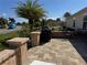 An outdoor patio area with a barbecue grill and a palm tree in the background at 1607 Quaker Ct, The Villages, FL 32163