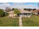 Backyard view of a single-story home with a screened-in porch and manicured lawn at 1739 Lake Villa Dr, Tavares, FL 32778