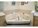 Luxurious bathroom featuring a spacious corner jacuzzi tub with tiled surround and elegant fixtures at 1739 Lake Villa Dr, Tavares, FL 32778