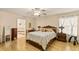 Comfortable bedroom with wood floors and a view into the attached bathroom at 1739 Lake Villa Dr, Tavares, FL 32778