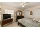 Neutral bedroom features a ceiling fan, large dresser and television at 1739 Lake Villa Dr, Tavares, FL 32778