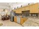 Well-lit kitchen with granite countertops, stainless steel appliances, and wooden cabinets, flowing into the dining area at 1739 Lake Villa Dr, Tavares, FL 32778