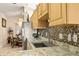 Close-up of granite countertops, stainless steel sink, and mosaic backsplash in a well-lit kitchen at 1739 Lake Villa Dr, Tavares, FL 32778