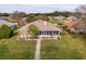 A home featuring a cozy screened-in porch, complemented by a well-manicured lawn and landscaped with potted plants at 1739 Lake Villa Dr, Tavares, FL 32778