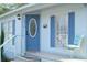 Charming home featuring a blue front door with decorative glass, complementary shutters, and welcoming porch seating at 1846 Fruitland Park Blvd, Fruitland Park, FL 34731