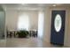 Bright living room featuring sheer curtains, comfortable seating, and a stylish front door, creating an inviting atmosphere at 1846 Fruitland Park Blvd, Fruitland Park, FL 34731