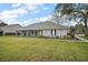 Exterior view of home with mature shrubbery, lawn and screened in lanai at 19215 Park Place Blvd, Eustis, FL 32736