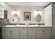 Elegant bathroom featuring a double vanity with granite countertop and oval mirrors at 19215 Park Place Blvd, Eustis, FL 32736