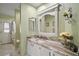 Bathroom features marble countertop, white cabinets, decorative mirror and neutral walls at 19215 Park Place Blvd, Eustis, FL 32736