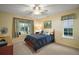 Cozy bedroom with a queen bed, ceiling fan, and natural light from two windows at 19215 Park Place Blvd, Eustis, FL 32736