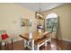 Bright dining room with large window, wood table, bench seating, and modern chandelier at 19215 Park Place Blvd, Eustis, FL 32736