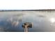 Scenic view of a private wooden dock on a serene, glassy lake reflecting the sky and clouds at 19215 Park Place Blvd, Eustis, FL 32736