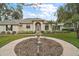 Elegant home featuring a well-maintained lawn, central fountain, and lush landscaping enhancing curb appeal at 19215 Park Place Blvd, Eustis, FL 32736