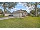 Exterior view of home with attached garage, driveway, mature shrubbery and green lawn at 19215 Park Place Blvd, Eustis, FL 32736