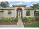 Inviting home exterior featuring arched windows, a decorative entryway, and manicured landscaping at 19215 Park Place Blvd, Eustis, FL 32736