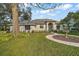 Charming single-story home with a circular driveway, lush lawn, and mature landscaping at 19215 Park Place Blvd, Eustis, FL 32736