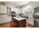 Well-lit kitchen featuring white cabinets, stainless steel appliances, island with seating, and hardwood floors at 19215 Park Place Blvd, Eustis, FL 32736