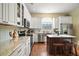 Well-equipped kitchen with stainless steel appliances, white cabinetry, granite countertops, and hardwood floors at 19215 Park Place Blvd, Eustis, FL 32736