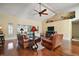 Inviting living room features hardwood floors, vaulted ceilings, ceiling fan, and comfortable leather seating at 19215 Park Place Blvd, Eustis, FL 32736