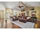 Spacious living room featuring hardwood floors, ceiling fan, and comfortable leather furniture at 19215 Park Place Blvd, Eustis, FL 32736