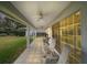 Covered patio featuring ceiling fans, tiled floor, and outdoor seating with views of the lush backyard at 19215 Park Place Blvd, Eustis, FL 32736