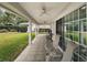 Covered patio featuring ceiling fans, tiled floor, and outdoor seating with views of the lush backyard at 19215 Park Place Blvd, Eustis, FL 32736