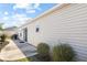 View of the home's exterior featuring durable vinyl siding and a side patio with well maintained landscaping at 1930 Rhett Rd, The Villages, FL 32163