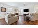 Spacious living room featuring wood floors, large windows, a ceiling fan, and comfortable seating at 1930 Rhett Rd, The Villages, FL 32163