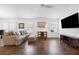 Cozy living room featuring wood floors, large windows, and comfortable seating arrangements at 1930 Rhett Rd, The Villages, FL 32163