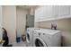 Bright laundry room featuring a washer, dryer, utility sink, and ample cabinet space at 202 Camino Real Blvd # 202, Howey In The Hills, FL 34737