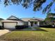 Charming single-story home with a well-maintained lawn, attached garage, and a welcoming red front door at 2041 Park Forest Blvd, Mount Dora, FL 32757