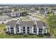 Aerial of condo buildings with lush landscaping, parking, and surrounding neighborhood at 2130 Cascades Blvd # 101, Kissimmee, FL 34741