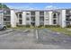 Exterior view of a well-maintained apartment building with accessible parking and landscaped grounds at 2130 Cascades Blvd # 101, Kissimmee, FL 34741