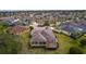 Aerial view of home highlighting screened-in lanai, lush lawn, and close proximity to other well-maintained properties at 2190 Derringer Ave, The Villages, FL 32162