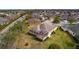 An aerial image showcasing the house, its screened-in patio, a beautiful lawn, and proximity to the main road at 2190 Derringer Ave, The Villages, FL 32162