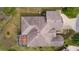 Aerial view of the property highlights its roof design, screened-in lanai and well-maintained outdoor space at 2190 Derringer Ave, The Villages, FL 32162