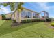 The backyard features a sunroom, screened lanai, and neatly trimmed hedges at 2190 Derringer Ave, The Villages, FL 32162