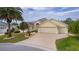 Traditional home with an attached three-car garage, manicured landscaping, and a patterned driveway at 2190 Derringer Ave, The Villages, FL 32162