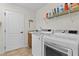 Well-lit laundry room featuring a modern washer and dryer set with shelving and ample storage space at 2190 Derringer Ave, The Villages, FL 32162