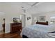 Bright main bedroom featuring hardwood floors, ceiling fan, and flat screen TV on wood dresser at 2190 Derringer Ave, The Villages, FL 32162