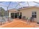 Large patio with a screened-in enclosure, seating, and sliding glass doors to the home's interior at 2190 Derringer Ave, The Villages, FL 32162