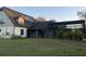 Rear view of the home highlighting the screened-in patio, solar panels, and spacious yard at 22244 County Road 455, Howey In The Hills, FL 34737