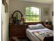 Bright bedroom featuring a large window, dresser, and comfortable bed with character blanket at 22244 County Road 455, Howey In The Hills, FL 34737