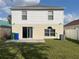 View of the home's backyard featuring a sliding glass door and well-maintained lawn at 2320 Whispering Trails Pl, Winter Haven, FL 33884