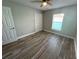 Bedroom with wood-look tile flooring and natural light, complemented by a ceiling fan at 2320 Whispering Trails Pl, Winter Haven, FL 33884