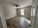 Bedroom featuring wood-look tile floors, a ceiling fan, and ample natural light from the window at 2320 Whispering Trails Pl, Winter Haven, FL 33884