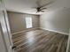 Bedroom featuring wood-look tile, ceiling fan, and a window providing natural light at 2320 Whispering Trails Pl, Winter Haven, FL 33884