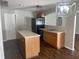 Kitchen with stainless steel appliances, wooden cabinets, kitchen island, and dark flooring at 2320 Whispering Trails Pl, Winter Haven, FL 33884