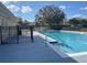 A fenced outdoor community pool with lounge chairs is surrounded by mature trees at 2320 Whispering Trails Pl, Winter Haven, FL 33884